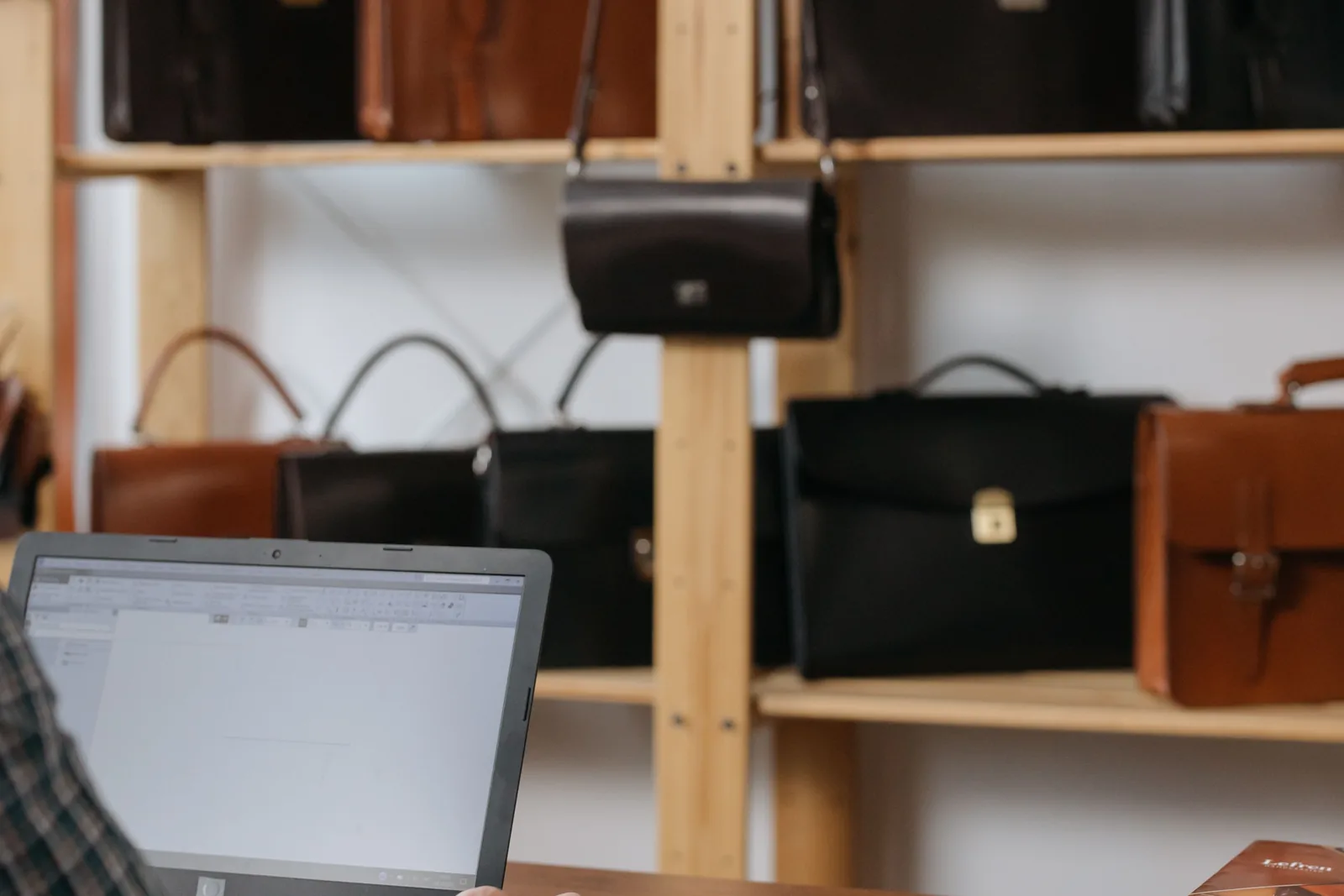Digital tools for a local small business A small business owner using a laptop inside his Montreal-style retail workshop.